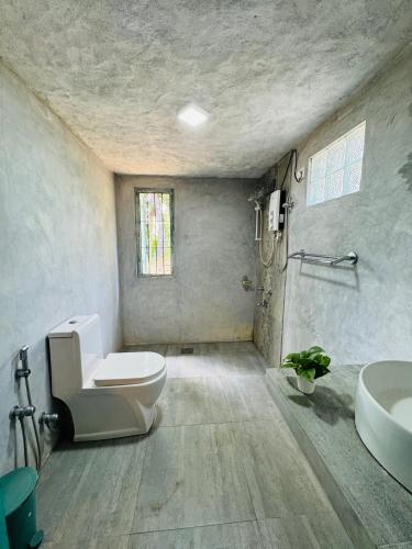 a bathroom with a toilet and a sink at Villa Ceylora in Busse