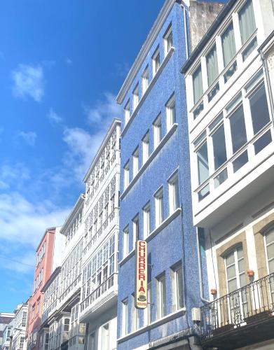 a blue building with a sign on the side of it at El Patio de María in Ferrol