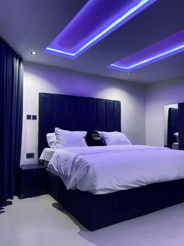 a bedroom with a large bed with purple lighting at Spike apartments in Jibowu