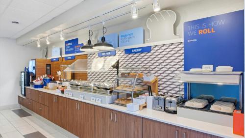 a bakery with a counter in a store with food at Holiday Inn Express & Suites Bethlehem Airport-Allentown Area in Bethlehem
