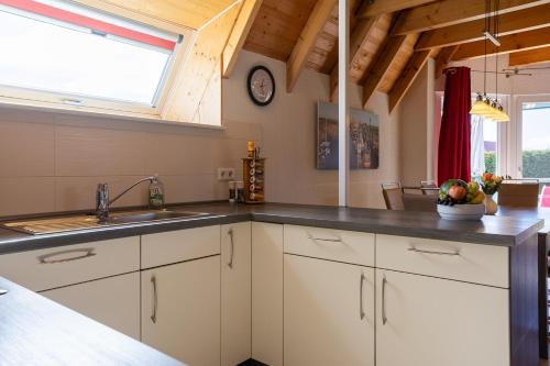 a kitchen with white cabinets and a sink and a window at Ferienhaus Klapötke in Dorum-Neufeld