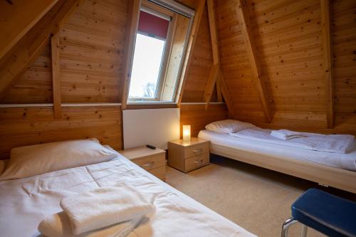 a bedroom with two beds in a wooden cabin at Ferienhaus Klapötke in Dorum-Neufeld