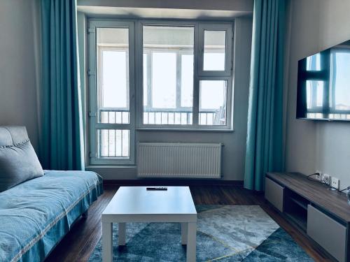 a living room with a couch and a coffee table at Comfy apartment near central train station in Ulaanbaatar