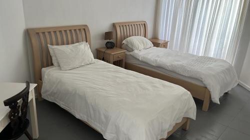 two beds in a room with two nightstands sidx sidx sidx sidx at Pearly Beach House in Plettenberg Bay