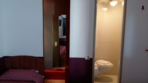 baño pequeño con aseo y cama en Bonsaï Hotel d'Orleans, en Olivet