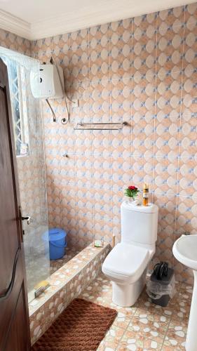 a bathroom with a toilet and a shower at llc APARTMENT in Kumasi