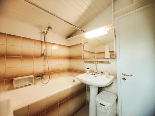 a bathroom with a sink and a bath tub at Spiti Mata in Perítheia