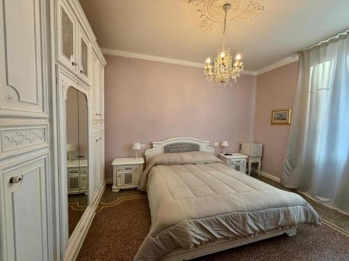 a bedroom with a large bed and a chandelier at B&B Elisir in Albenga