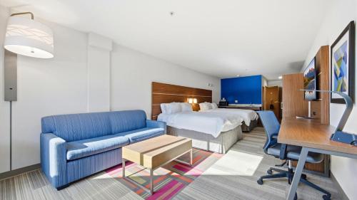a hotel room with a bed and a couch and a desk at Holiday Inn Express & Suites Bethlehem Airport-Allentown Area in Bethlehem