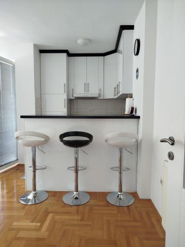 a kitchen with a counter and two bar stools at Smjestaj_S in Bijeljina