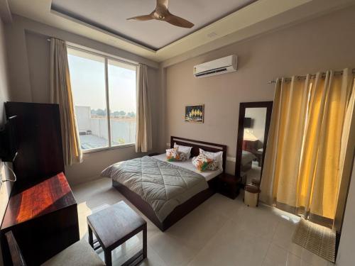 a bedroom with a bed and a large window at Summit Springs Resorts in Bagru