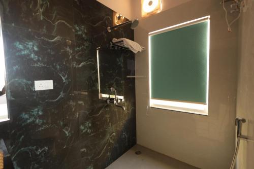 a bathroom with a black stone wall and a window at Summit Springs Resorts in Bagru