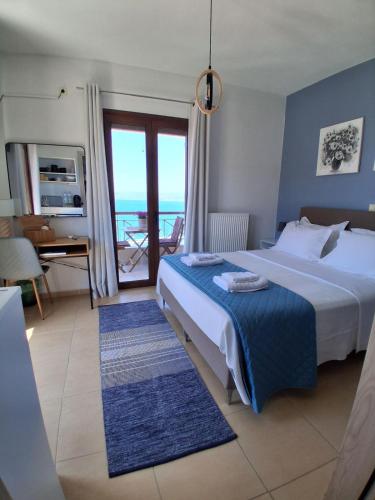 a bedroom with a bed and a view of the ocean at Bay blue in Pylos