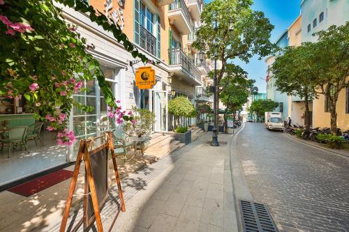 a city street with tables and chairs and buildings at Casa Del Mar Hotel & Apartment - Sunset Town, Phu Quoc in Phú Quốc