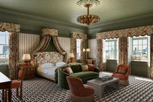 a bedroom with a bed and a couch and a chandelier at The Stoneleigh, Autograph Collection in Dallas