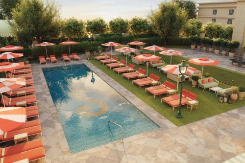 an overhead view of a pool with chairs and umbrellas at The Stoneleigh, Autograph Collection in Dallas