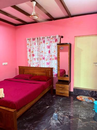 a pink bedroom with a bed and a mirror at Dishaa Estate View Home Stay in Madikeri