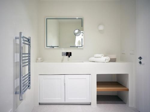 a bathroom with a white sink and a mirror at Villa Katy in Aspro Chorio Paros