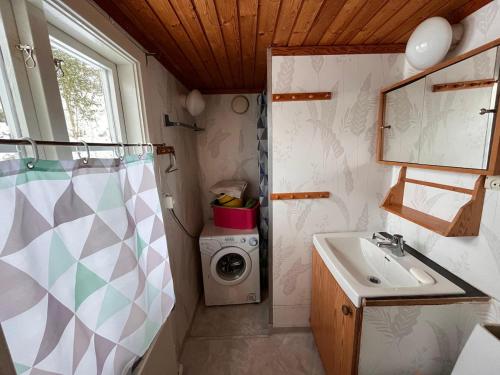 a bathroom with a sink and a washing machine at Cozy farmhouse with rowboat! in Skönberga