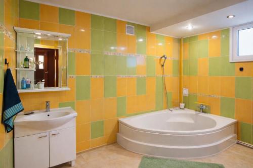 a bathroom with a tub and a sink at Guest House Asahi in Stryi