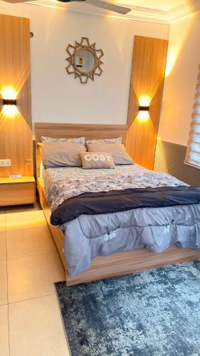 a bedroom with a large bed with two lights on it at llc APARTMENT in Kumasi