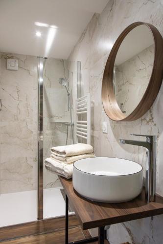 a bathroom with a large round mirror and a tub at Le Clos de Narco in Vernosc-lès-Annonay