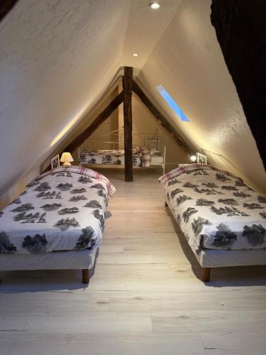 two beds in a room with a attic at Les Meublés d'Etigny in Luchon