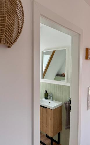 a bathroom with a sink and a mirror at Designer chalet with gorgeous Eifel panorama in Kerschenbach