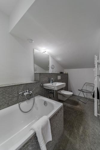 a bathroom with a tub and a sink and a toilet at Chesa Nair - Surlej in Surlej
