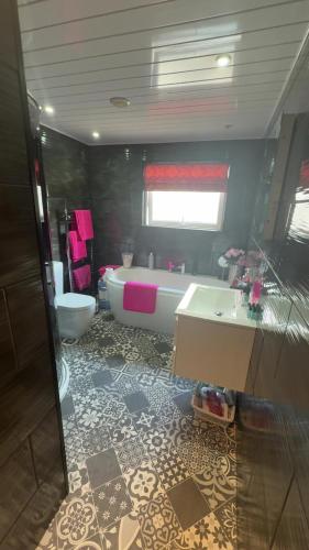 a bathroom with a tub and a toilet and a sink at Fairwinds in Inverness