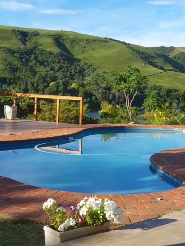 a blue swimming pool with a mountain in the background at Chickpea Villa in Bergview