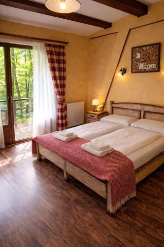 a bedroom with two beds and a large window at Pensiune Restaurant Lyra in Corunca