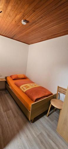 a bed in a room with a wooden ceiling at Ferienwohnung Glashauser in Biedenkopf