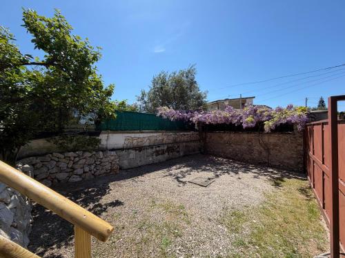 a garden with purple flowers on a fence at Casa Glicine in Sperlonga