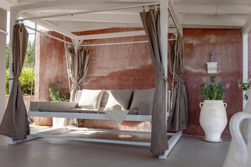 a swinging bed in a room with a wall at Villa Theros in Ierapetra