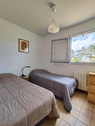 a bedroom with two beds and a window at Résidence le safran in Erdeven