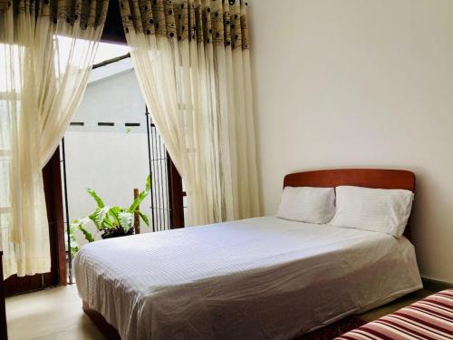 a bedroom with a bed and a large window at Sky Mansion Athurugiriya in Athurugiriya