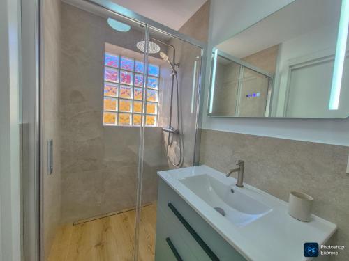 a bathroom with a sink and a glass shower at Casa Del Sol in Águilas