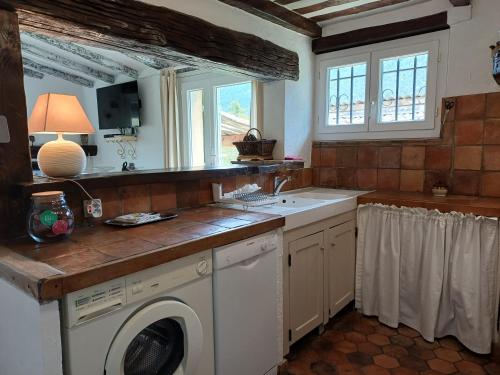 a kitchen with a washing machine and a sink at Villa la Myreclose in Saint-Auban