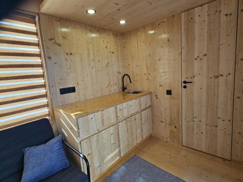 a small room with a sink and wooden walls at Piestātne Riverside Cabins with Sauna, Hot Tub & Private Pier in Katlakalns