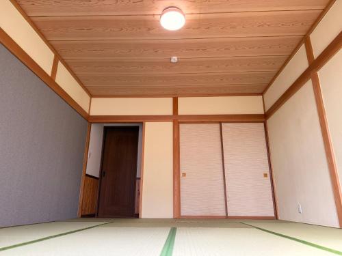 an empty room with a wooden ceiling and a door at BBQ屋根付き大型ウッドデッキ川のせせらぎを聴きながら贅沢時間ペット同伴OK森と音に癒されるコテージ Rill in Nasu