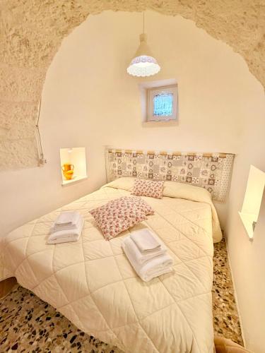 a bedroom with a bed with two towels on it at Trulli Fenice in Martina Franca