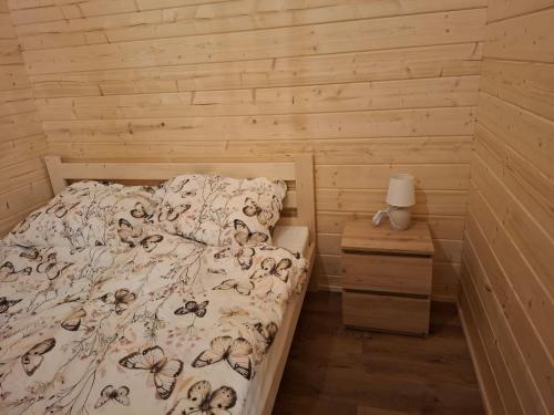 a bedroom with a bed and a wooden wall at Chata Zbója - Sidzina in Sidzina