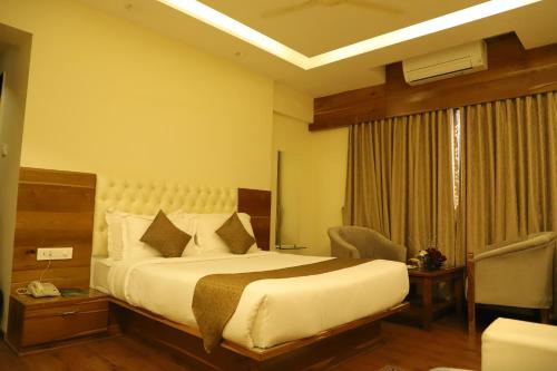 a hotel room with a bed and a window at Sai Neem Tree Hotel in Shirdi
