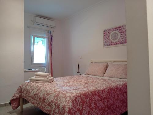 a bedroom with a bed with a red blanket and a window at Maria's House Kontokali in Kontokali