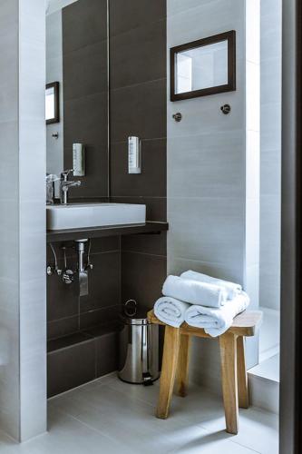 a bathroom with a sink and a table with towels at Hotel zur Amtspforte in Stadthagen