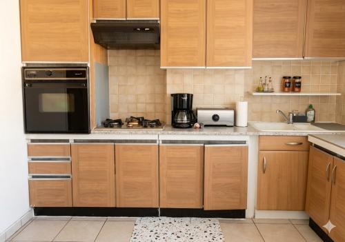 una cucina con mobili in legno e un microonde nero di Au Bon Pasteur a Cholet