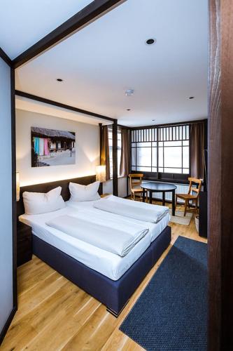 a bedroom with a large bed and a table at Hotel zur Amtspforte in Stadthagen