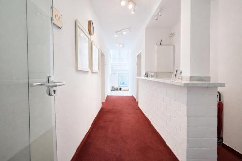 a corridor with a red carpet in a white hallway at Airport Messe Villa Casa in Düsseldorf