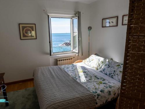 a bedroom with a bed with a view of the ocean at Ochin de Ma' a Boccadasse - Genovainrelax in Genoa